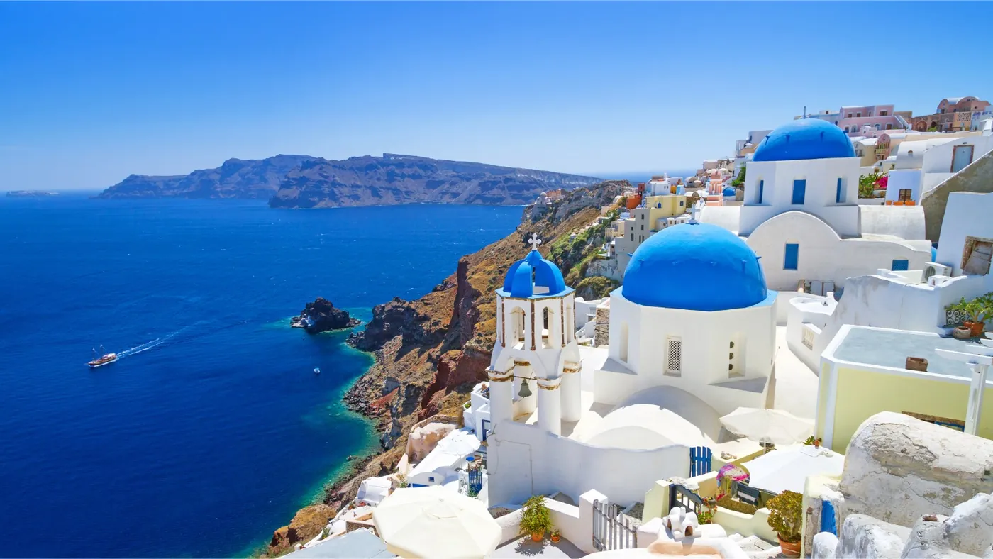 Greece Golden Visa residency by investment, view of Greek coastline and traditional architecture