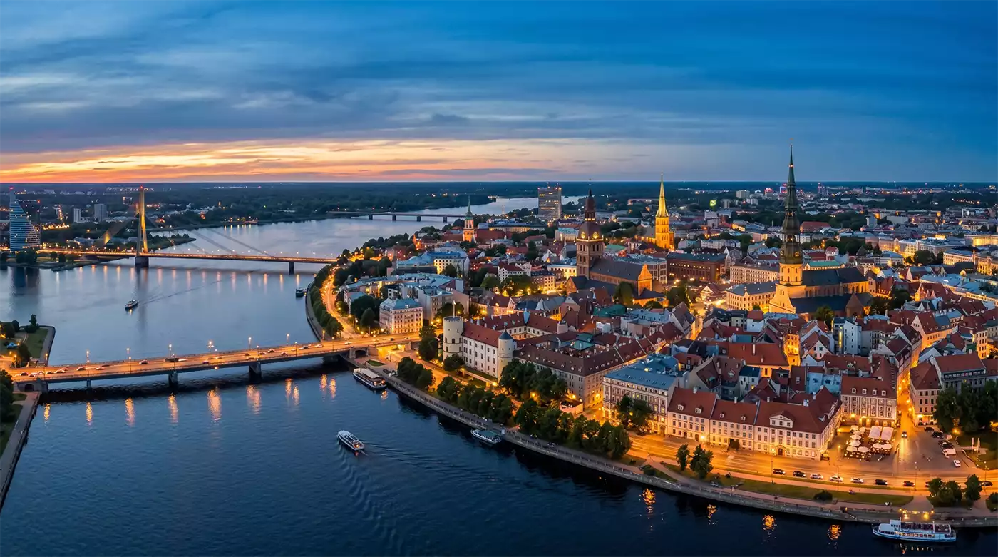 Latvia Golden Visa: Riga Old Town skyline at dusk viewed from the Daugava River